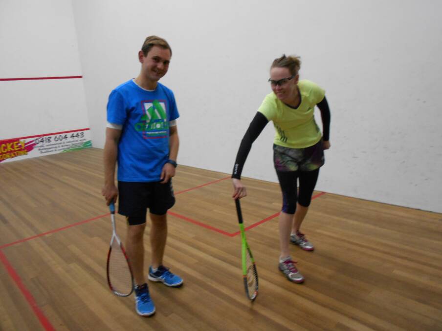 SPIN IT: Graeme Andrews and Angela Bennett spin the racket to choose who will serve first. Photo supplied. 