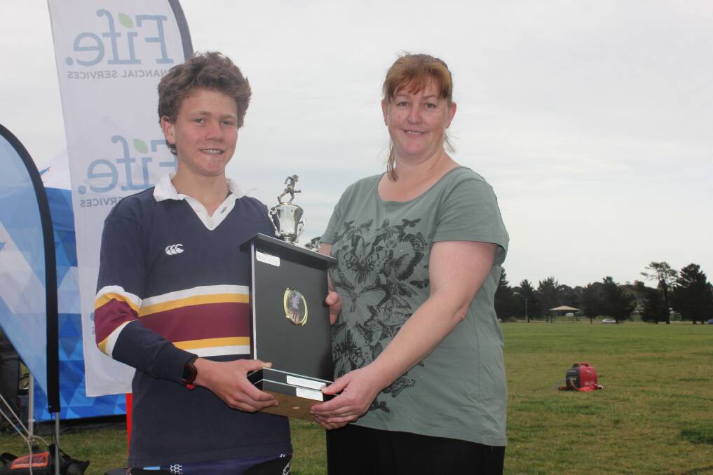 TRIBUTE: Local runner Jonathan Mooore accepts the Peter Oberg Memorial Trophy from Peter’s sister Christine Elward. Moore participated in the 10km run with a time of 37:46. 