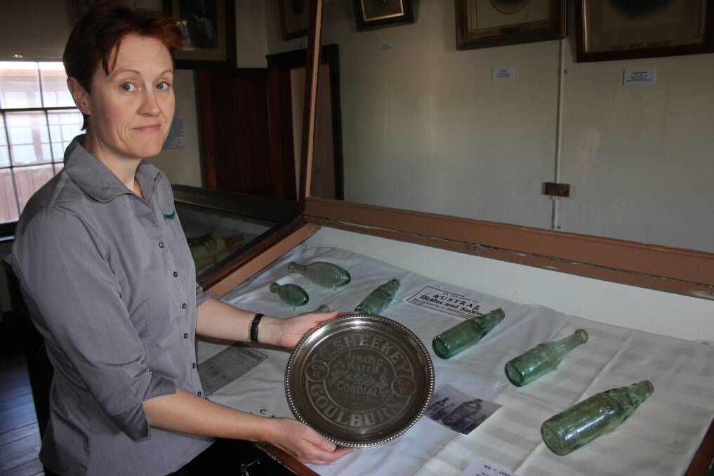 ANCIENT TRADE: Goulburn Mulwaree museums officer Claire Baddeley with some items in a new exhibition at St Clair Villa Museum about Goulburn’s early cordial manufacturers. 