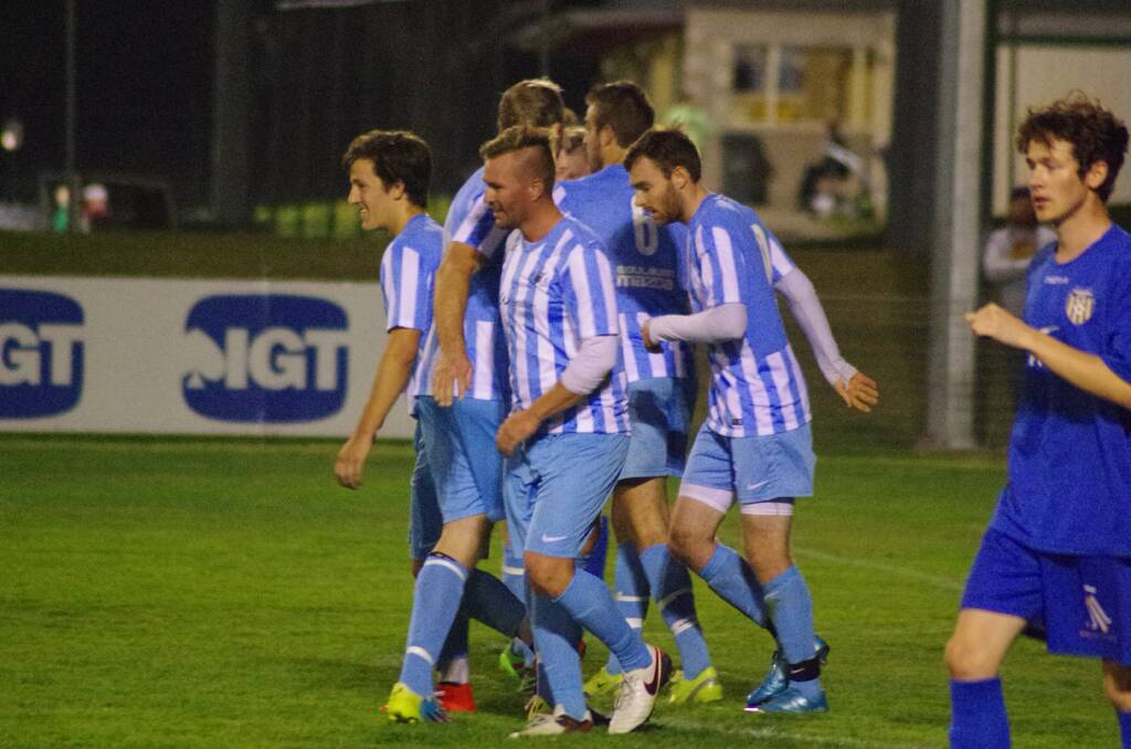 HEADS HIGH: Ryan Gardner, Robert Dorsett who scored the equalizer, Aaron Swanson and other swans players head back for the restart after congratulating Dorsett in the First FFA Cup game to be held in Goulburn. Photo: Darryl Fernance