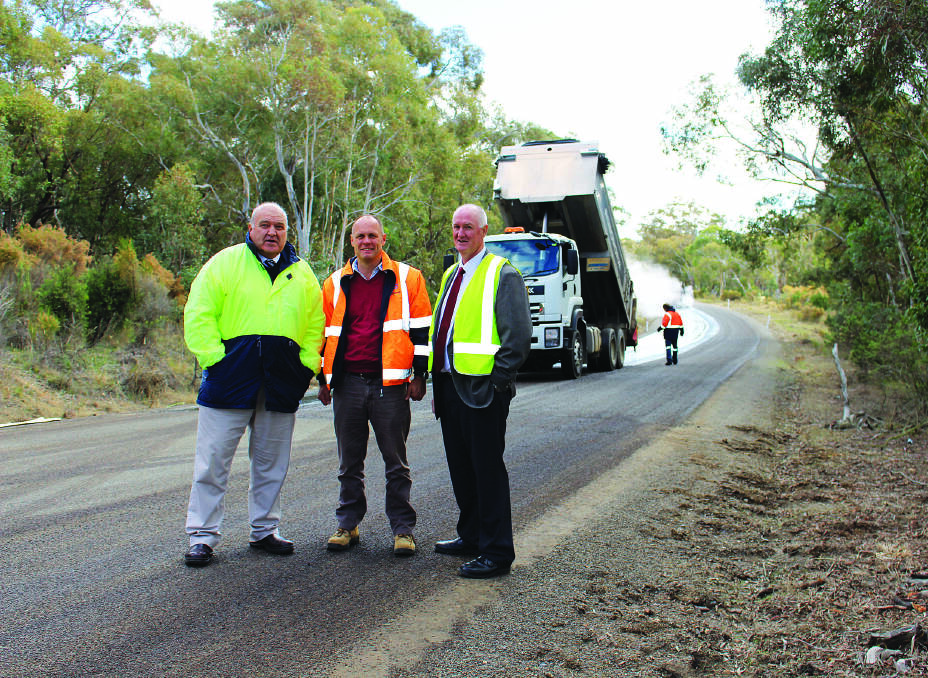 SAFER: Upper Lachlan Shire Council’s works director Phil Newham, Gullen Range wind farm’s asset manager Tom Frood and council general manager John Bell on Range Road.