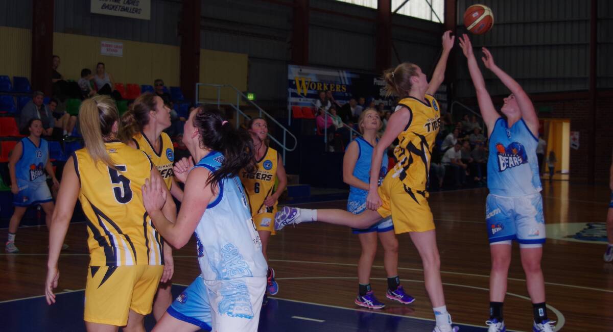 Goulburn’s Jordan Huntley has a shot attempt knocked off target by Shoalhaven’s Lucy Marron during the action packed game on Saturday. In the foreground Kathryn Cudaj attempts to box out two of the Tigers. Photo: Darryl Fernance.

