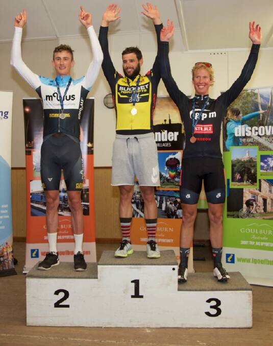 WINNERS: Jacob Kaufmann (Manly/Warringah Cycle Club, centre) stands on the winners podium inside the Marulan Community Hall with second placed Samuel Burston (left) and third placed Edward White (right). 
