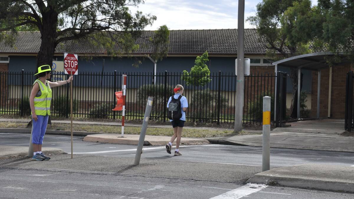 SAFETY FIRST: A traffic controller employed by the Roads and Maritime Service ensures safe passage for Goulburn North Public School students each weekday morning. 