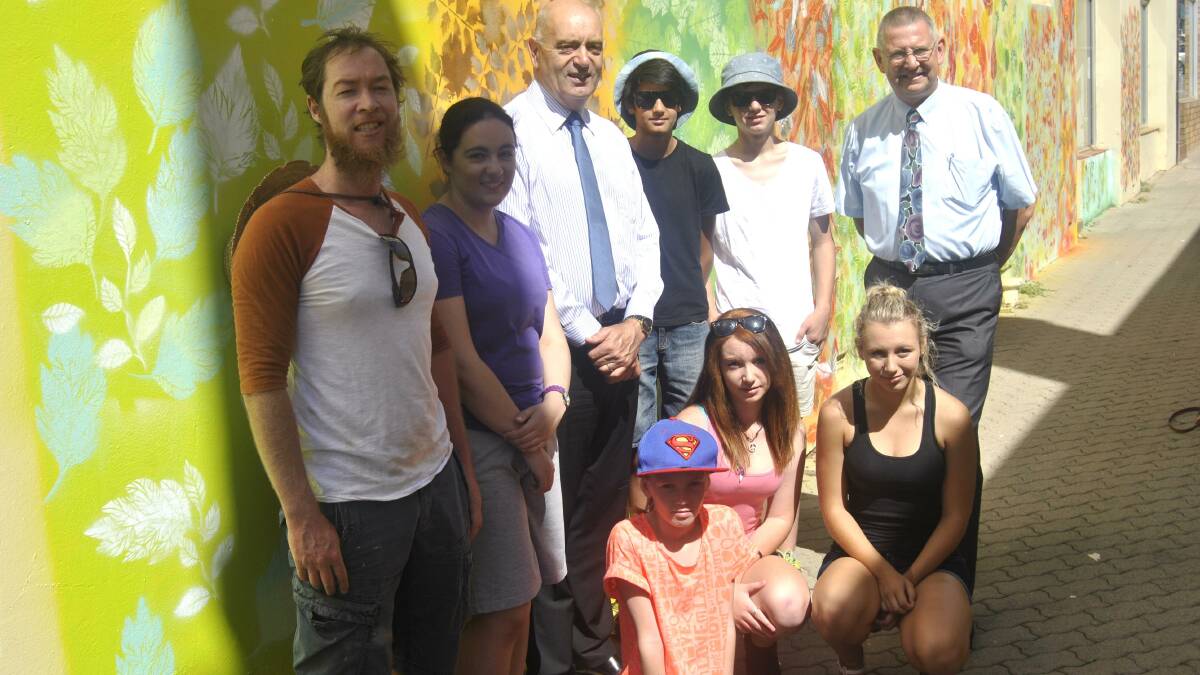 
Sydney artist Jason Wing (left) enjoyed a break whilst painting a mural in Russell Lane on Friday morning. He was joined by Council General Manager Warwick Bennett (centre) and Mayor Geoff Kettle (right) along with Joshua Adam and Harry Way (back), and (front) Rori Baig, Xanthe Britton and Hanna Shawyer
