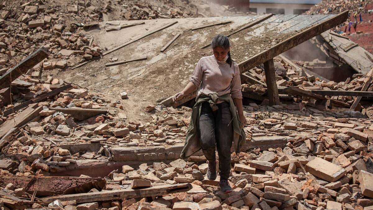 A volunteer walks on top of the debris of a collapsed temple at Basantapur Durbar Square on April 27, 2015 in Kathmandu, Nepal. (Photo by Omar Havana/Getty Images)