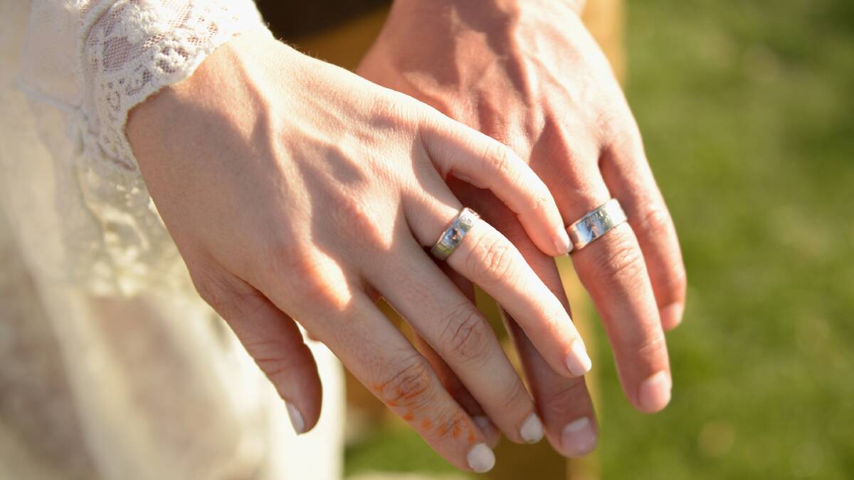 A couple exchange wedding rings. Photo: Getty Images