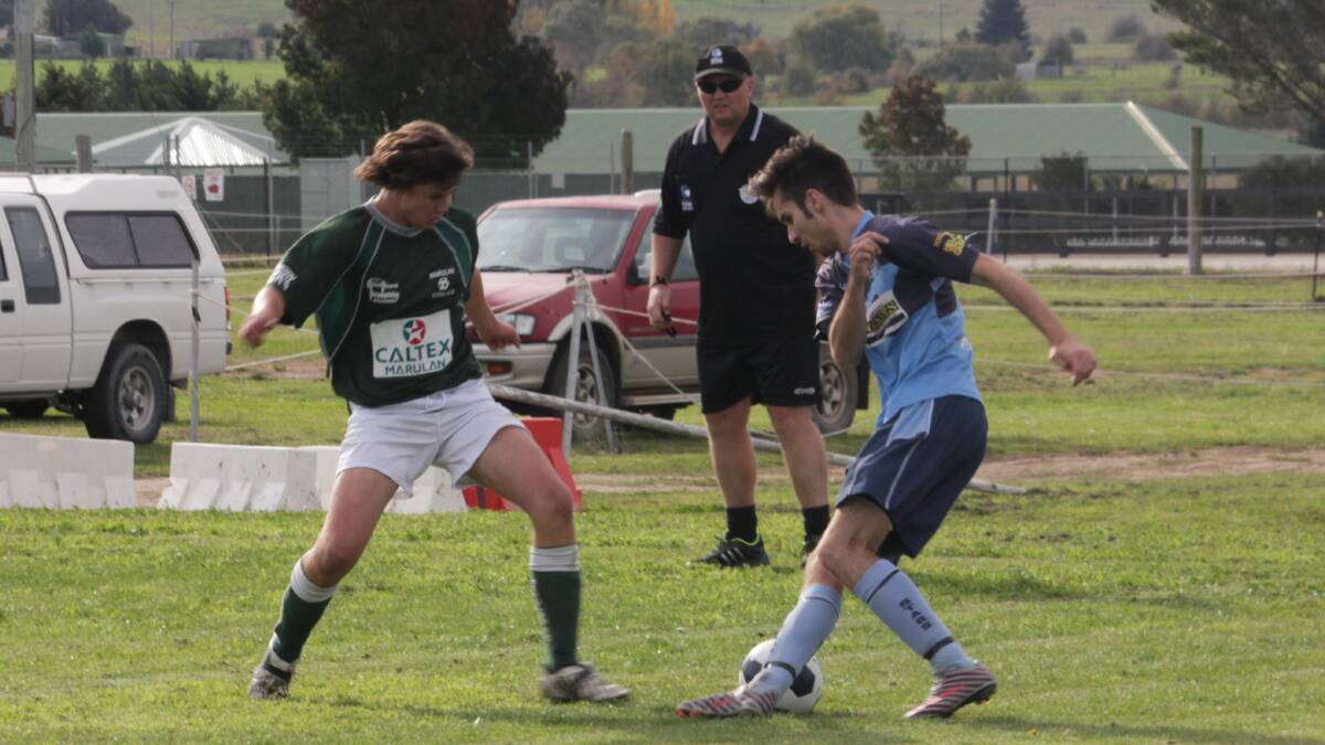 HARD AT IT: A Marulan player (left) and a Stag Prem
player (right) challenge for the ball at the Super 8
Soccer tournament at Cookbundoon last Saturday.
Photo: Antony Dubber.