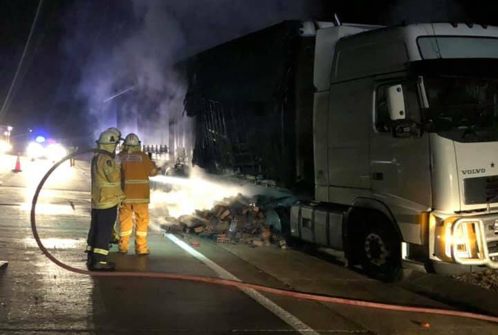 Members of Gunning and Oolong Rural Fire Brigades fight the fire that started underneath the A-trailer of a B-double truck carrying bricks. Photo: Gunning Rural Fire Brigade