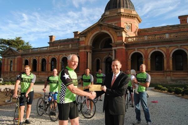Mark Howard is pictured presenting a cheque to the value of $2000 to Goulburn Cycle Club members Matt Hanson, Jason Kain, Jim Hoskins, Terry Bennett, Andy Cartwright, Rod McWhirter, Fred McClelland and his daughter Katie.