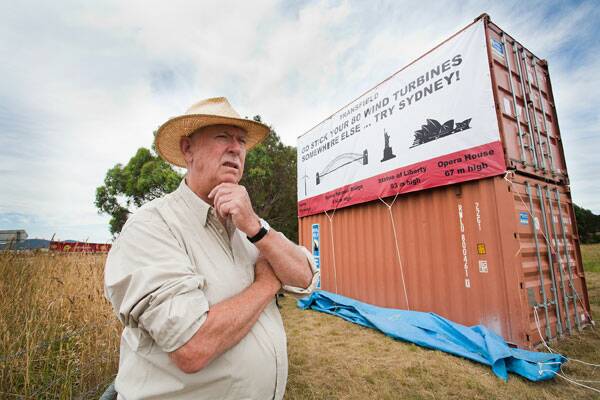 COMMUNITY VOICE: Friends of Collector chairman Tony Hodgson next to his new billboard on the Federal Highway. The community group is calling for the wind farm to be scrapped.