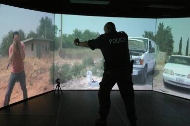 TARGET SIGHTED: Sgt Garry Handsaker subdues a virtual car thief with a virtual oc spray. Photo: Darryl Fernance.