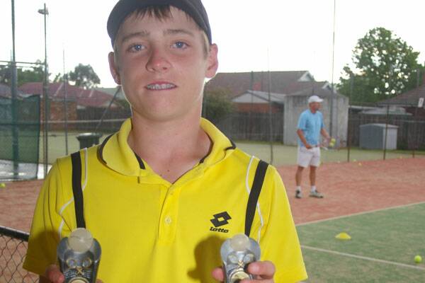 WINNER: Charlie Reardon displays his 12 years and under boys ACT Junior Tennis trophies at the Bishop St Tennis Courts on Tuesday night only hours after his finals matches.