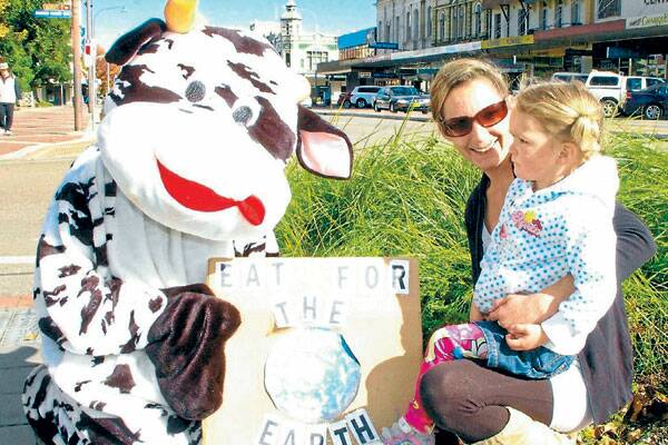 • AWARENESS: Animal advocate Suki Jones (in the cow costume) talks to Saray Ardly and her daughter Ciann, 3, during the factory farm awareness walk stopover yesterday.