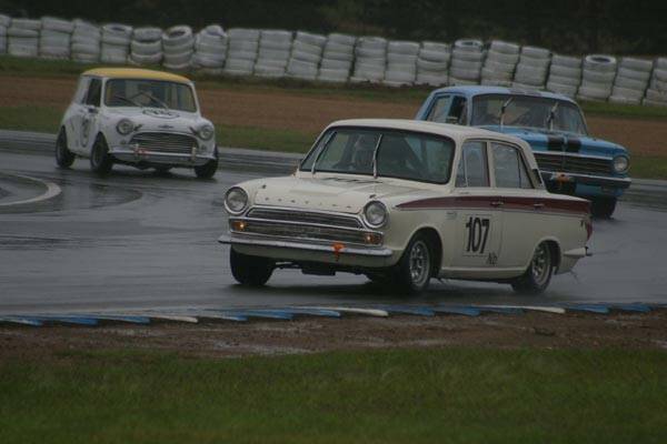 SLIPPERY CONDITIONS: Kerry Hughes in his 1964 Ford Cortina GT heads a group of cars during the