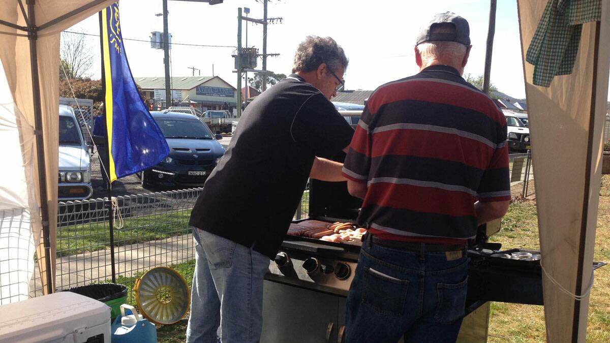 Mark Hazelgrove and John O'Connor serve up some bacon and egg rolls. Photo BRITTANY MURPHY.