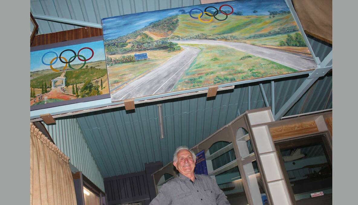  ASPIRATIONS: Tony Lamarra stands beneath murals, painted by inmates at Goulburn Jail, depicting how the Olympic rings would look on display at the Hume Highway. 