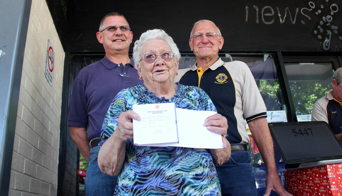 First prize ... volunteer raffle ticket seller Val Finlay with Goulburn Mulwaree Mayor Geoff Kettle and Lions Club of Goulburn City treasurer Ken Anderson, with the first prize ticket from this year’s Christmas Raffle. 