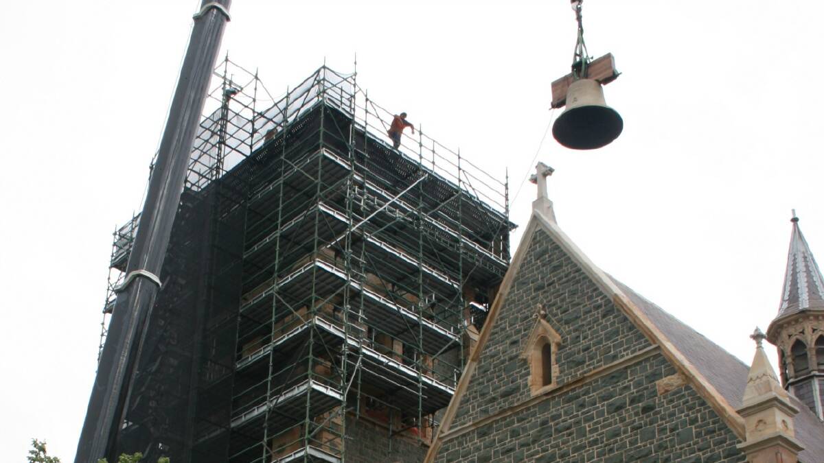  A crane operator starts the delicate task of lifting the two-tonne Murphy Bell into Sts Peter and Paul’s Old Cathedral tower on Monday
