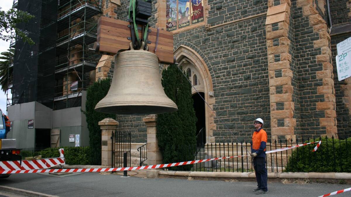 A crane operator starts the delicate task of lifting the two-tonne Murphy Bell into Sts Peter and Paul’s Old Cathedral tower on Monday