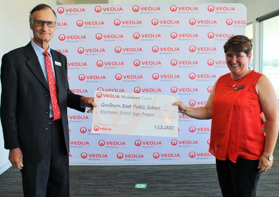 Veolia Mulwaree Trustee John Reynolds in 2020 presented Goulburn East Public School assistant principal Bronwyn Robinson with a $12,000 cheque to purchase an electronic signboard for the school. Photo: supplied.
