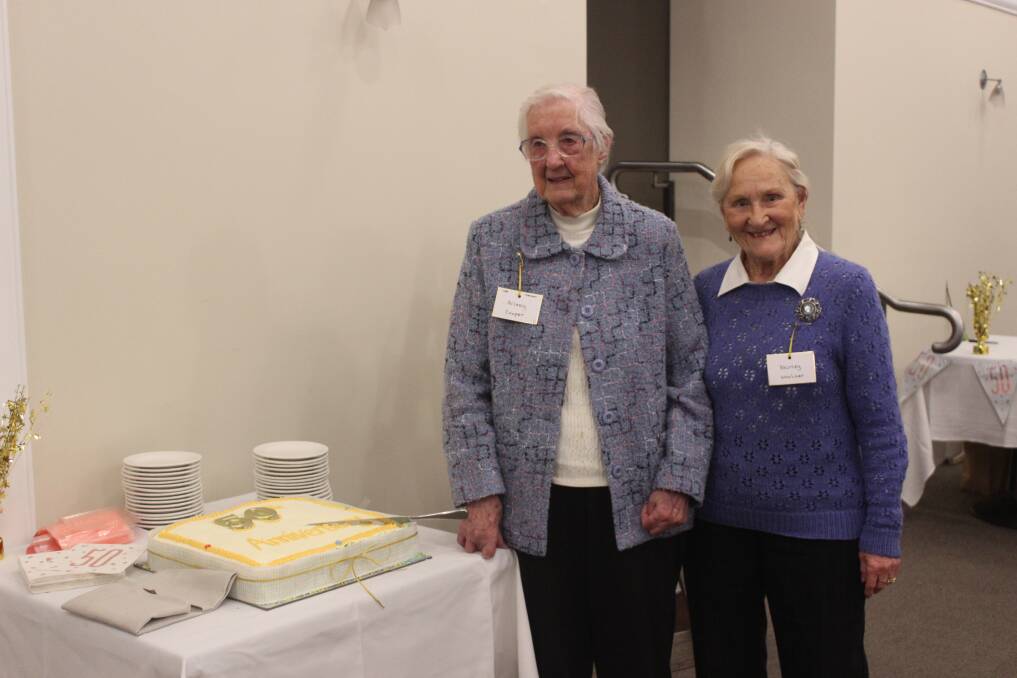 Long-standing members Aileen Cooper (who is 94-years-old) and Shirley Woolner cutting the cake. Photo: Sophie Bennett.