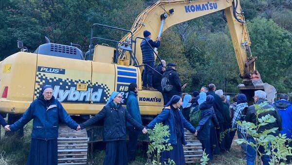 Nuns in Saint-Pierre-de-Colombier, Ardèche protect an excavator so work on the construction of the large religious centre can continue. Picture via France 3