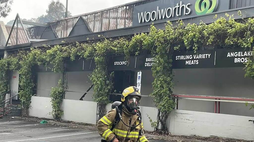 A firefighter in front of the destroyed Woolworths supermarket. Picture by Country Fire Service