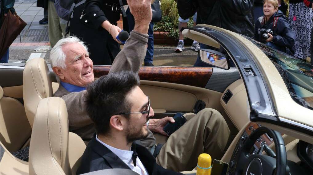 BOND LEGACY: George Lazenby waves at the crowd surrounding his car for the inaugural SpyFest in Goulburn. Photo: Darryl Fernance.