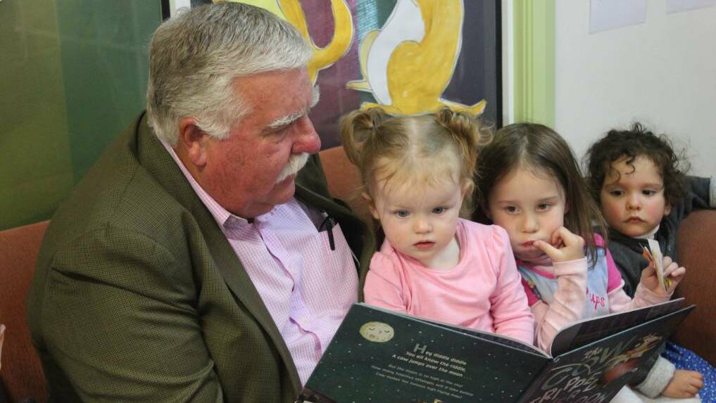LITERACY: Big Fat Smile Chairman David Campbell reads 'The Cow Tripped over the Moon' to Hannah Croker, 1, a student of the Reynolds Street Community Preschool as part of the National Simultaneous Storytime. Photo: Mariam Koslayy.