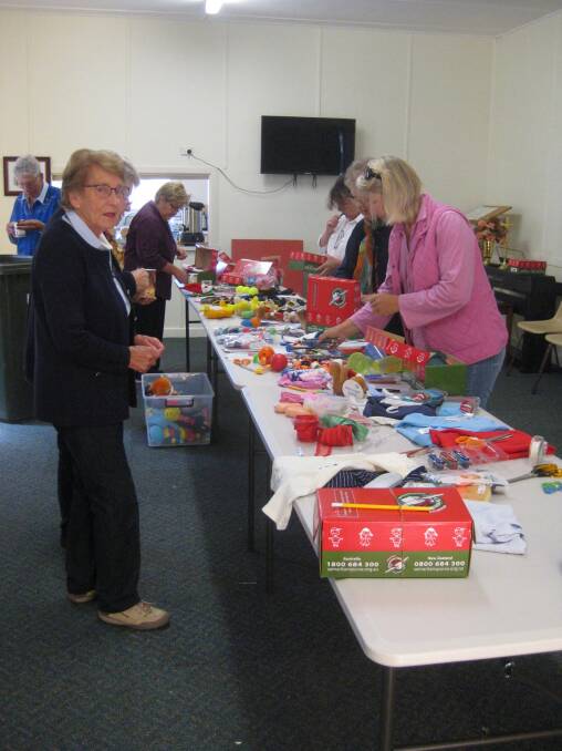 GOOD CAUSE: Operation Christmas Child organiser Lesley Johnson with volunteers packing up Christmas gifts for impoverished children.