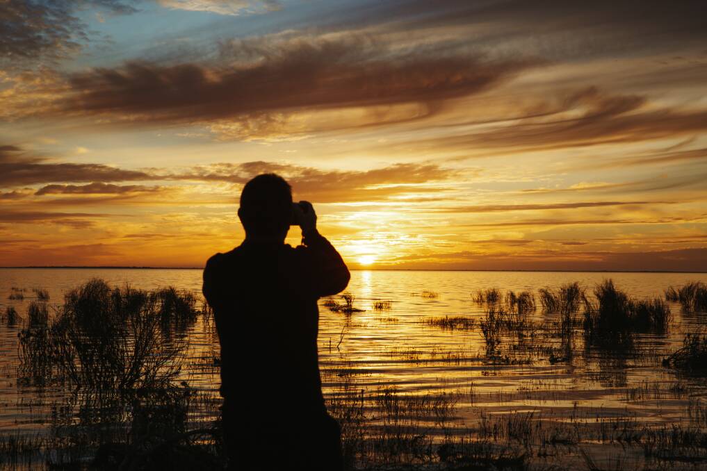 A visitor takes in the sunset over Menindee Lake. Picture: Dion Georgopoulos