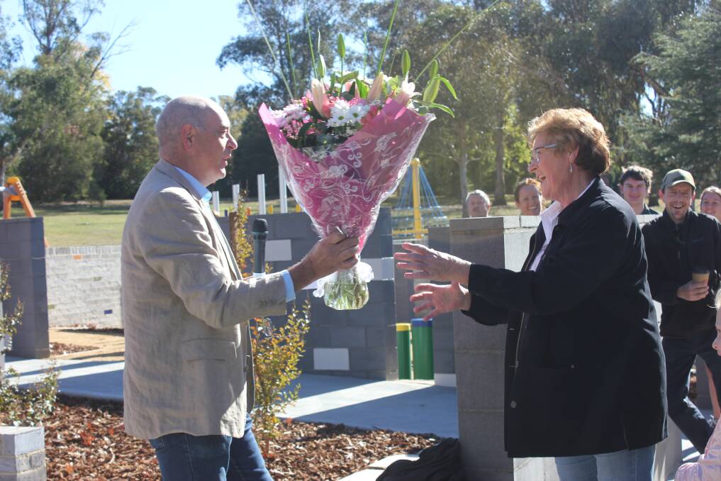 Goulburn Mulwaree Council General manager Warwick Bennett gives Bob Kirk's wife Christel flowers for the 45th anniversary.
