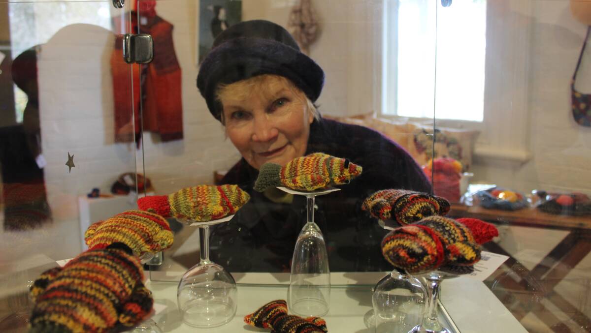 GOOD CATCH: Carol Divall looks at the woolen swimming fish as part of the Wonders of Wool exhibition. Photo: Mariam Koslay. 