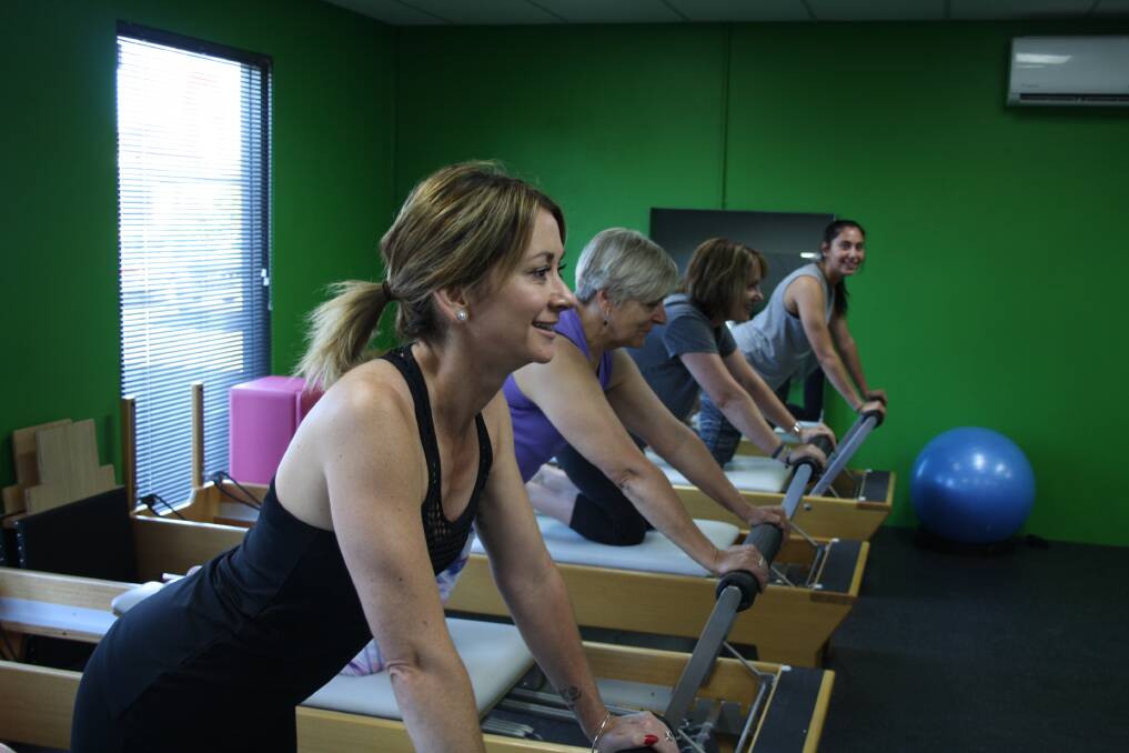 STRONG AND SUPPLE: M Pilates clients Bec Norris, Helen Peterson, Rose Bell and Caitlyn Vassallo using the Pilates reformers. 