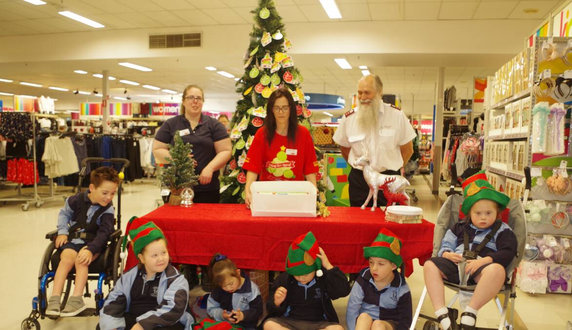 GOODWILL: Kmart store manager  Regina Blume, Wishing Tree Champion  Amanda Webb and Salvation Army representative, Captain Phillip McCall with The Crescent School students. Photo: Darryl Fernance.