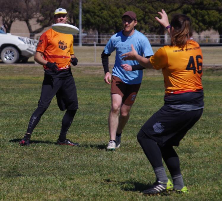 PASSING: A Newcastle Pie Wagon player attempts to intercept a pass between two  IWU Tarmac players from Tempe during a game on Saturday. Photo: Darryl Fernance