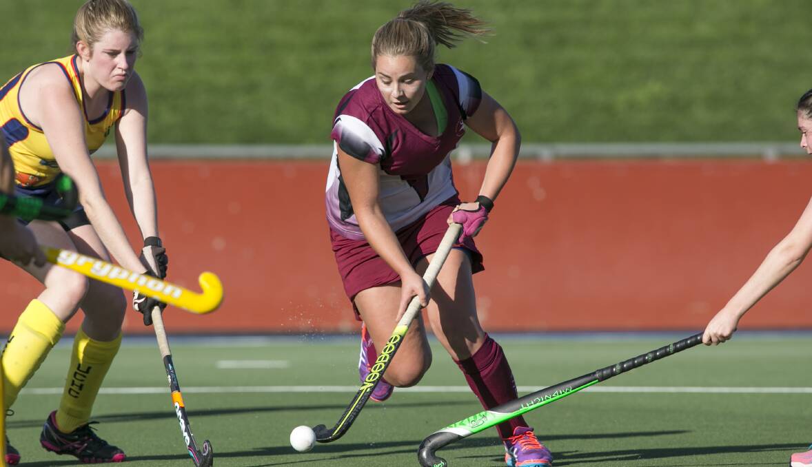WORLDS AHEAD: Laura Gray (maroon and white) playing for Tuggeranong Vikings Women's Hockey Club in the National Capital League  division one competition. Photo: Keegan Carroll