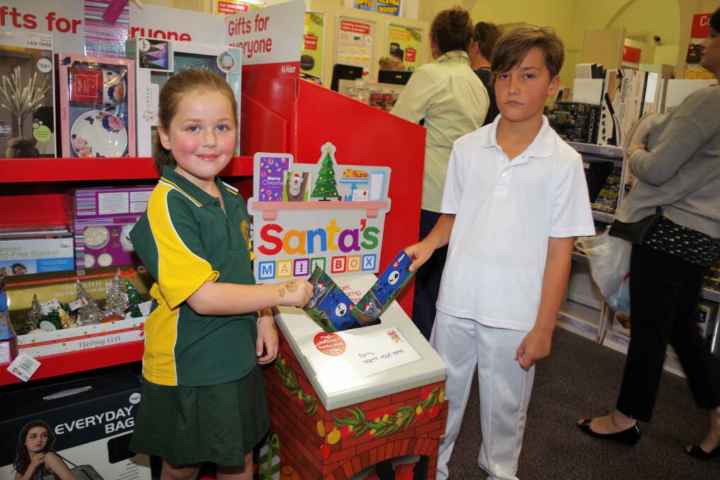 SANTA LETTERS: Bella Heycox and Ethan Waters pop their Santa letters into the special post box just inside Goulburn's Australia Post Office's front doors. Photo: Darryl Fernance
