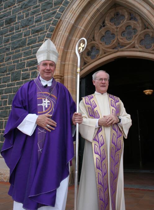 CHANGES: Father Dermid McDermott (right), pictured here with Archbishop Christopher Prowse at his 2013 installation, is retiring this month.