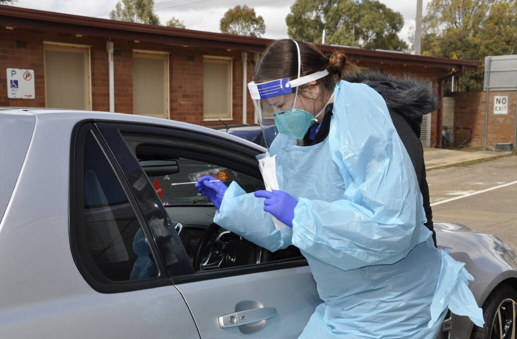 Capital Pathology collector Chloe Meagher administers a COVID-19 test at Goulburn's Bourke Street drive-through clinic on Wednesday. Photo: Louise Thrower. 