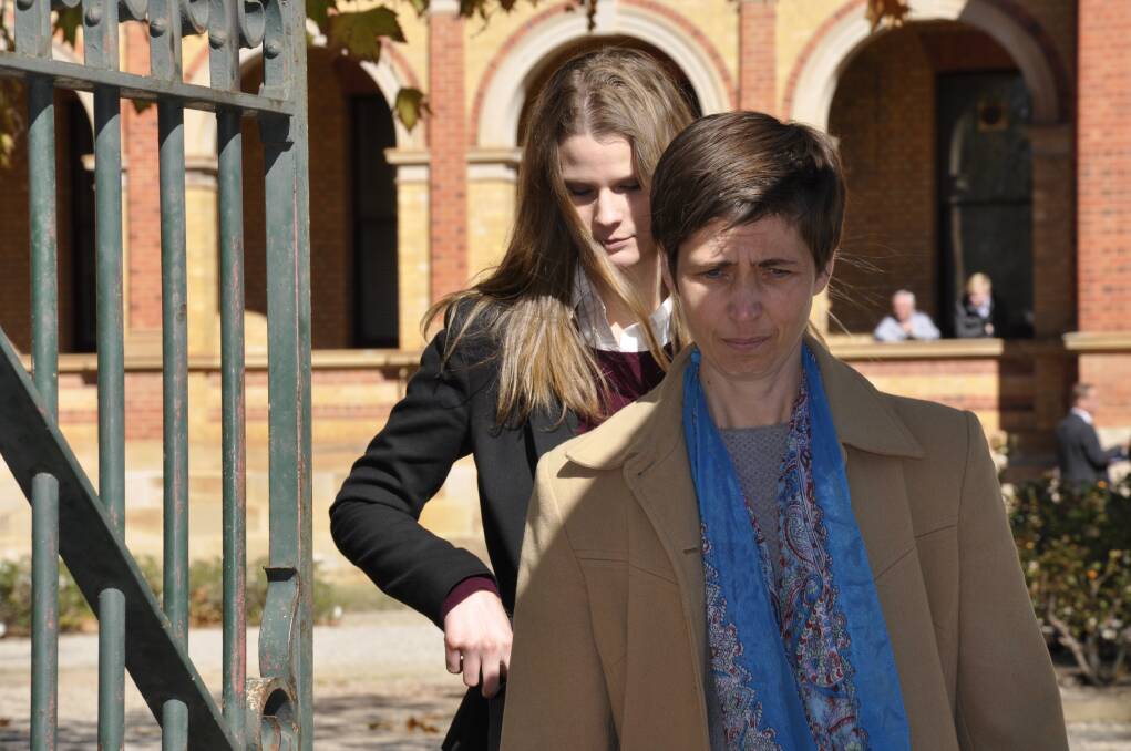 Gabrielle Mace (behind) and a supporter emerge from Goulburn Local Court after she was convicted of entering inclosed lands and interfering with the conduct of business and hindering police at Southern Meats in April. Photo: Louise Thrower.
