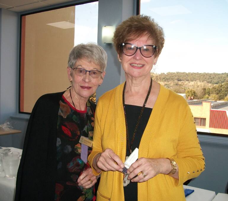 Carol Olsen (right) presented Colleen Bopping with her 10-year membership badge. 