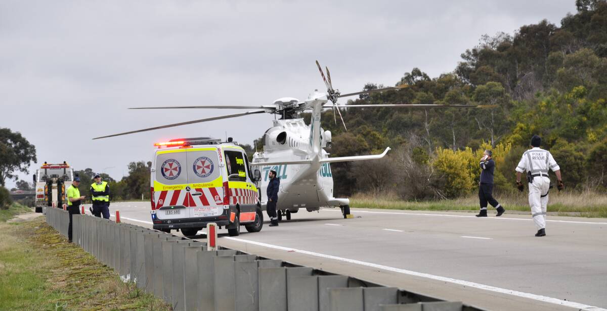 An ambulance helicopter landed at the scene to convey a man to a Canberra Hospital. Picture by Louise Thrower.