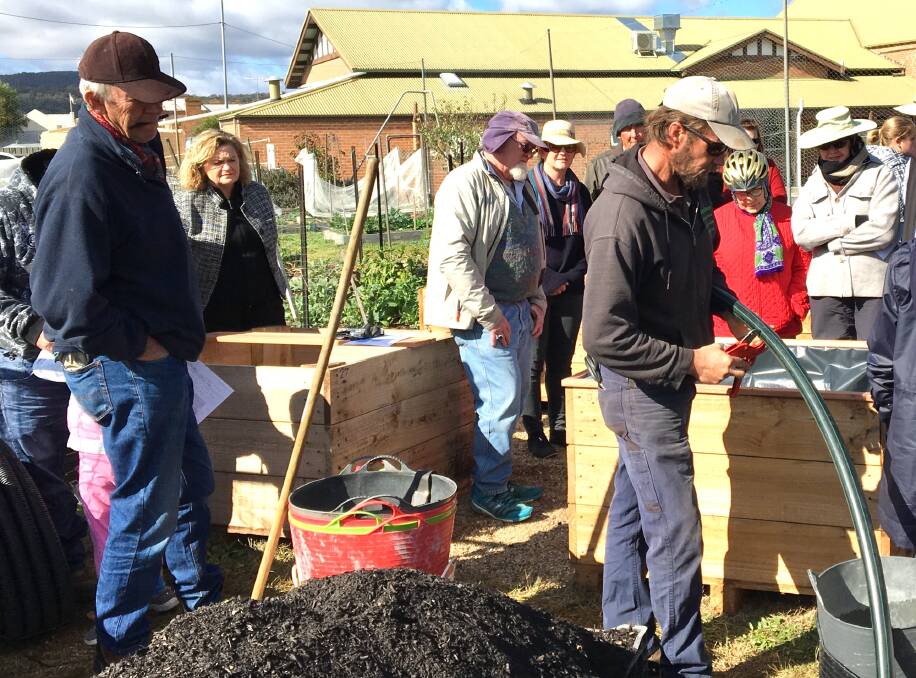 INSTRUCTION: Members of the community garden behind the Uniting Church gained insight into the construction of water wise wicking beds on Saturday. Photo: supplied.