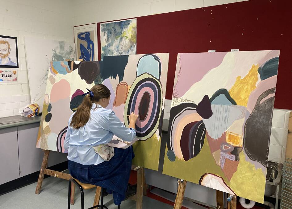 Tess McKenzie as a Trinity Catholic College student hard at work on her painting, which was selected in ArtExpress. Picture supplied.