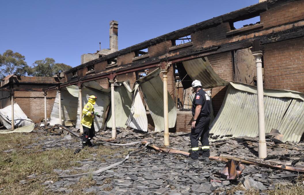 NSW Fire and Rescue personnel surveyed the aftermath of a blaze that destroyed the former female ward 15 at Kenmore Hospital on Saturday, October 16. Photo: Louise Thrower.