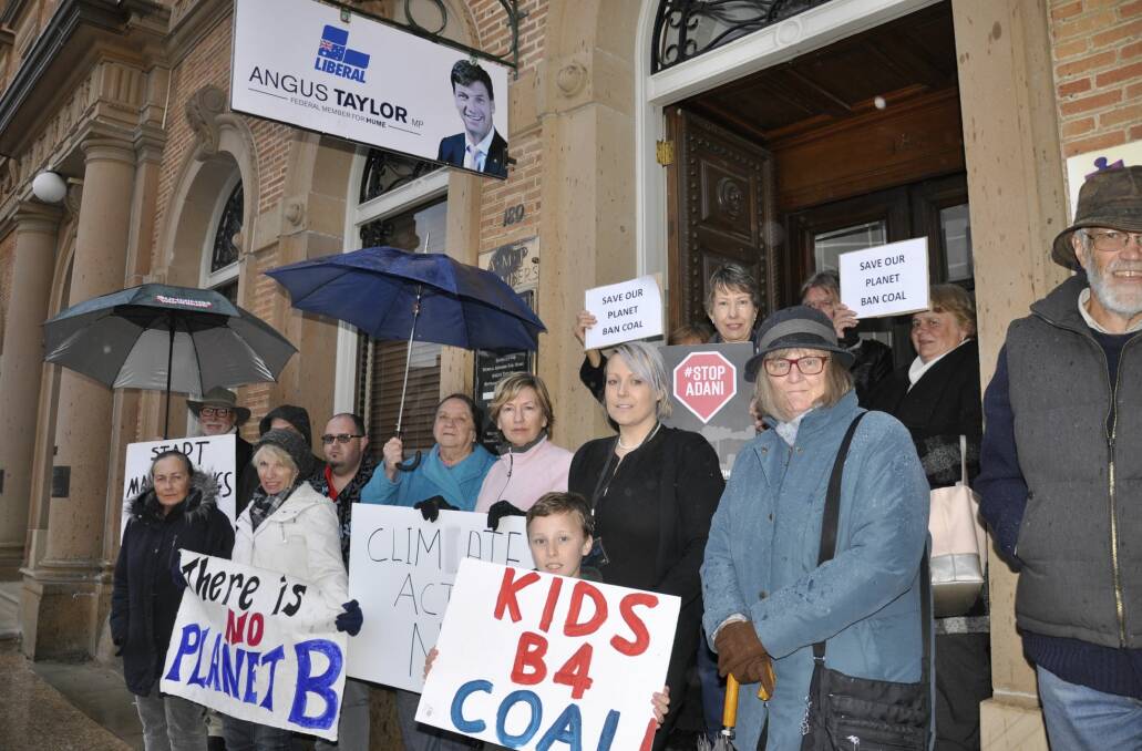 Supporters of Labor, The Greens and independent Huw Kingston, as well as several other community members rallied for greater action on climate change outside Liberal MP Angus Taylor's office on Friday. Photo: Louise Thrower. 
