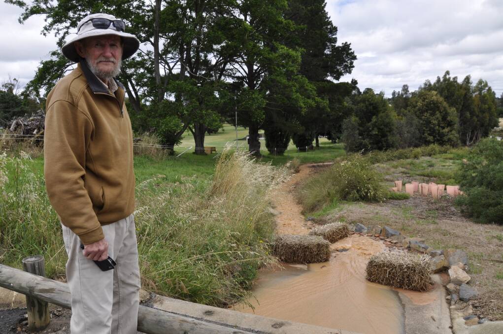 Friends of Goulburn Swamplands volunteer Bill Wilkes surveys the silted water being pumped into Goulburn wetlands from a May Street subdivision on Saturday morning. Photo: Louise Thrower.