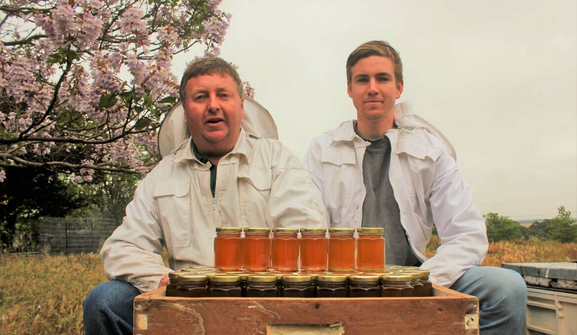 Gary Poile and son, Bradley, with their honey produced as part of the family business. Picture by Ainsleigh Sheridan.